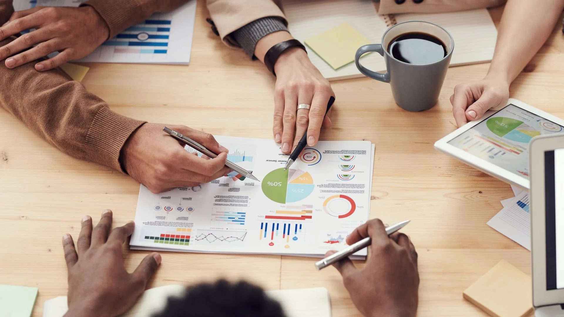 Personas revisando información de negocio en una mesa de trabajo